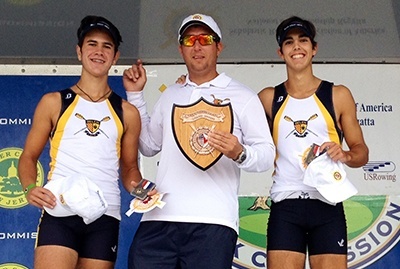 Posing after their gold medal win, Belen Jesuit's Varsity 2x crew, Joey Armengol, left, and Hector Formoso, right, with coach Yunian Cabrera.