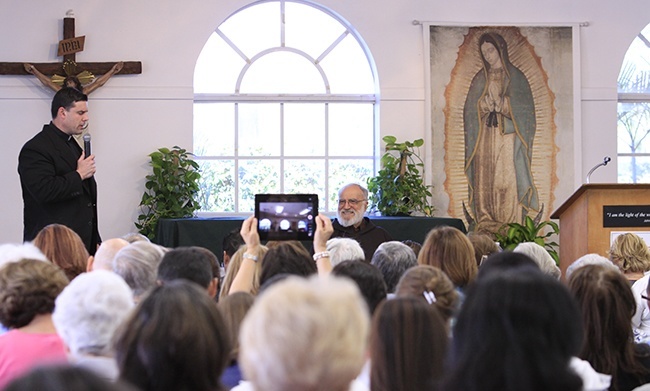 Piarist Father Rafael Capo, executive director of the Southeast Pastoral Institute (SEPI) for Hispanic Ministry, welcomes a crowd of about 200 lay people to the center to listen to the preacher of the papal household, Capuchin Franciscan Raniero Cantalamessa (seated).