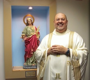 Father Marcos Somarriba stands with the new statue of St. Agatha.