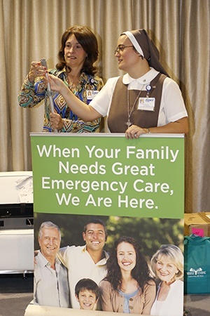 Alicia Ortiz, community outreach specialist at Mercy Hospital, and Sister Ana Laura Aguiar, who works in Mercy's Pastoral Care department, set up their display at the convocation.