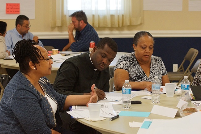 Msgr. Chanel Jeanty, archdiocesan chancellor for canonical affairs and also pastor of St. Philip Neri in Miami Gardens, sits with his staff to plan the next year in their parish.