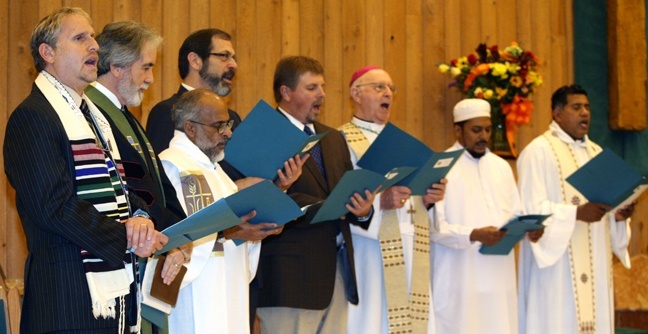 Rabbi Bradd Boxman of Congregation Kol Tikvah, Rev. Craig Watts of Royal Palm Christian Church, Father Mathew Thundathil of St. Andrew Parish, Rabbi Mark Gross of Temple Beth Orr, Pastor Randy Cutter of New Dawn Community Church, Bishop William Friend, retired bishop of Shreveport, La., Yazid Ali, of the Masjid Jama'at al-Mu'mineen, and Father George Puthusseril, pastor of St. Andrew, sing "God Bless America" at the conclusion of the annual Coral Springs pre-Thanksgiving Interfaith Unity